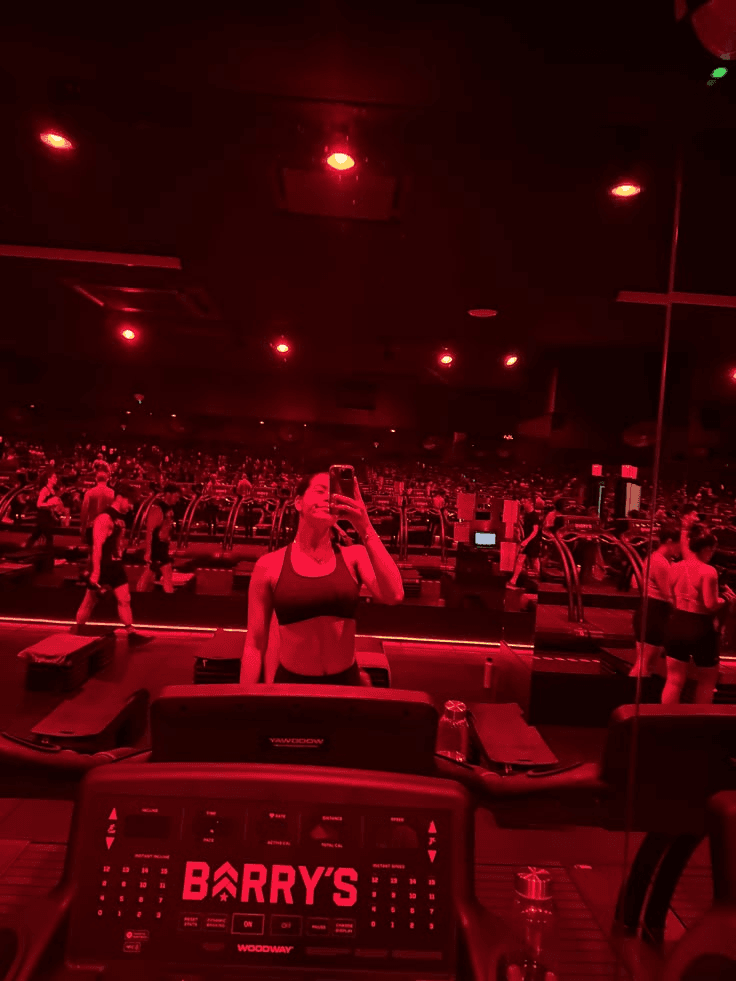 Fitness instructor in a red-lit boutique fitness studio